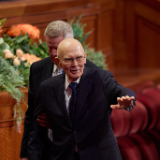 El presidente Dallin H. Oaks saluda a los asistentes en el Centro de Conferencias de la Manzana del Templo durante la Sesión de sábado por la tarde de la Conferencia General 196 de la Iglesia de Jesucristo.